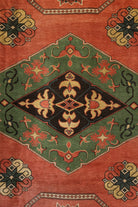 Close-up of a patterned rug with geometric designs on a red and green background.